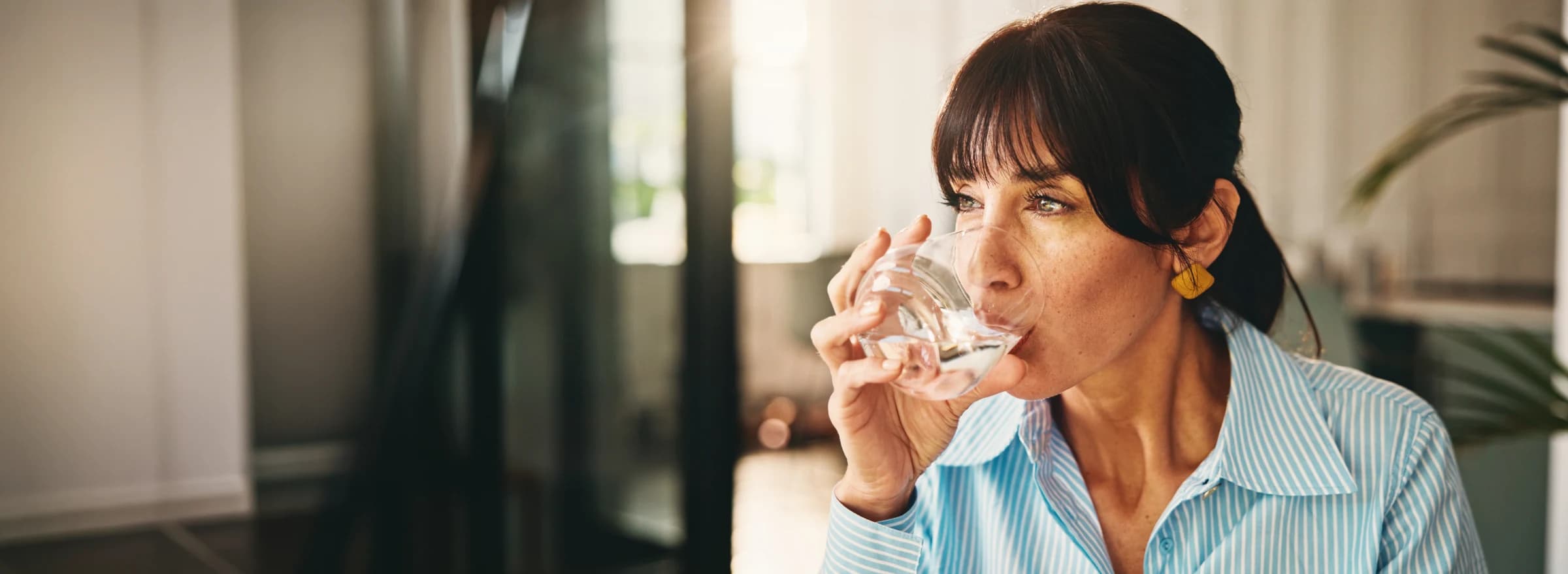Frau trinkt sauberes gefiltertes Wasser